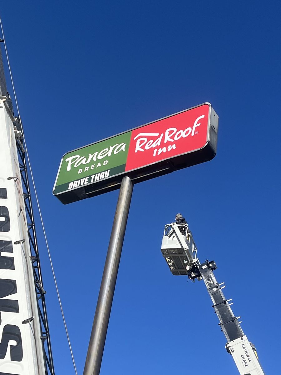 Cook Neon crew installing a pylon sign with a crane truck